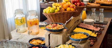 Un bufé con diversas frutas, verduras y productos para el desayuno.