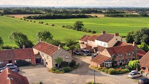 A rural property with multiple brick houses, a large green field, and a gravel driveway. - Barker Stakes Farm B&B (Pickering)