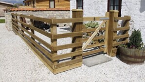 A wooden gate with a number 8, a stone wall, and a building with a tiled roof. - Barker Stakes Farm B&B (Pickering)