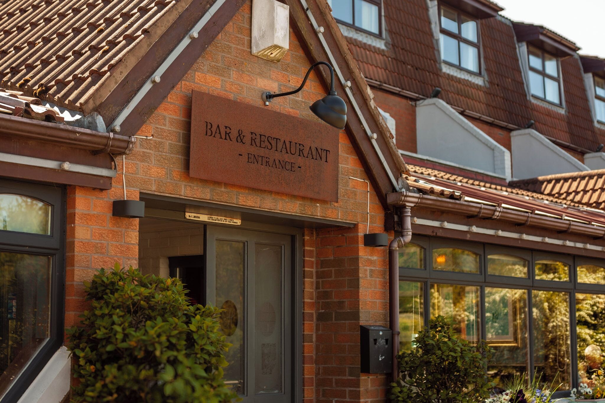 Un edificio de ladrillo con un cartel que dice 'BAR & RESTAURANT - ENTRADA'.