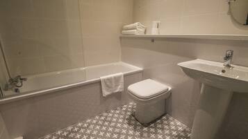 Une salle de bain avec une baignoire, des toilettes et un lavabo.
