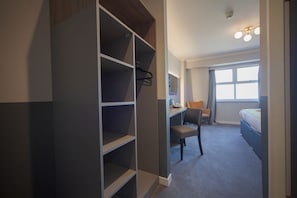 Escritorio, cortinas blackout y tabla de planchar con plancha