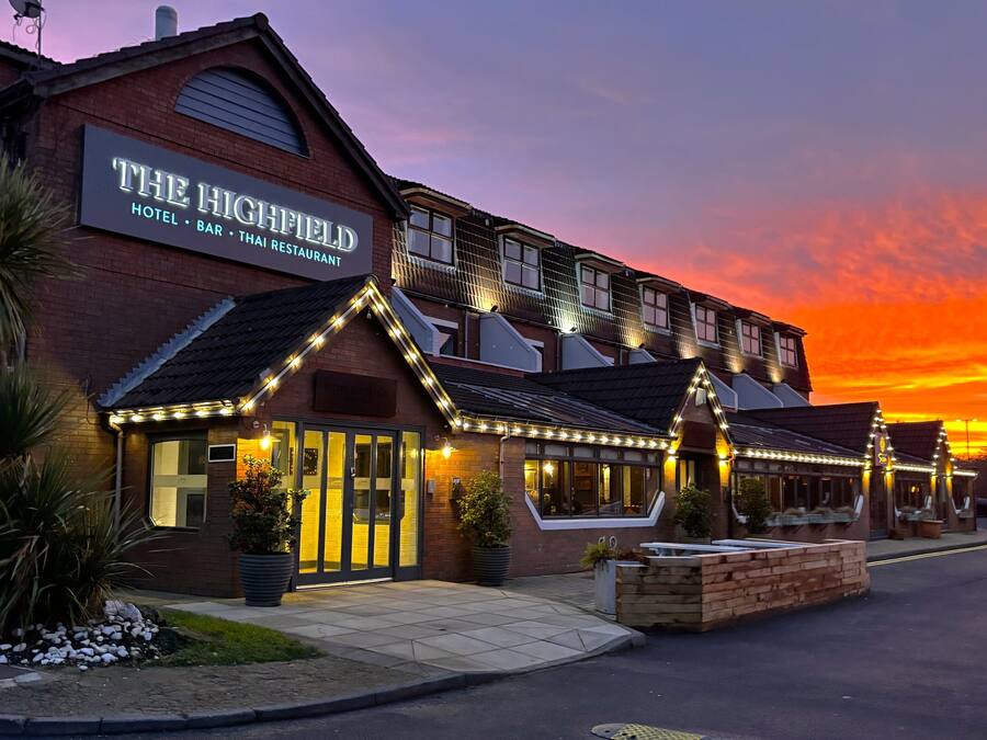 A hotel with a sign reading "The Highfield Hotel Bar Thai Restaurant."