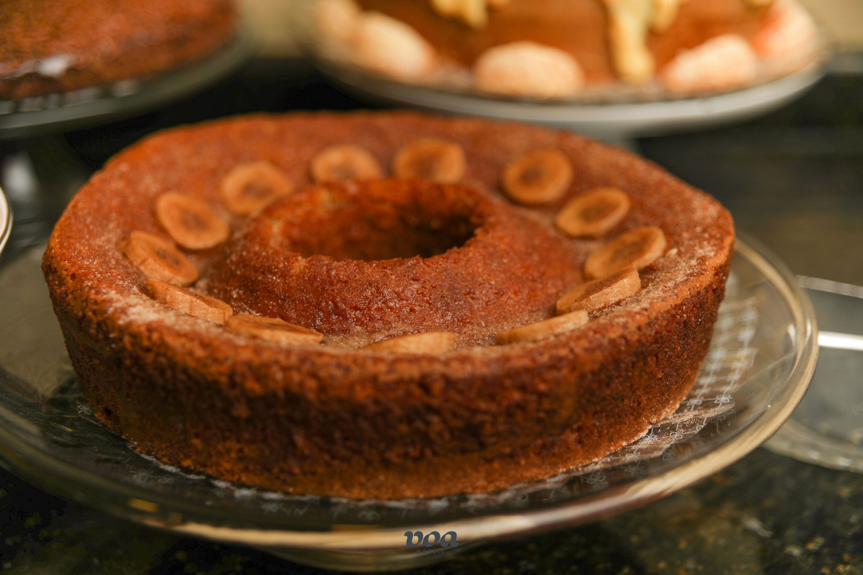 Een taart met een ring bananenschijfjes op een glazen bord.