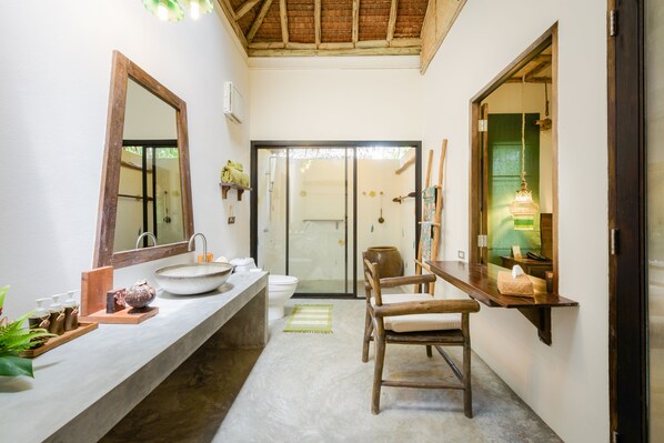 A bathroom with a large mirror, a sink, a toilet, and a wooden chair. - Koh Yao Yai Village (Ko Yao)