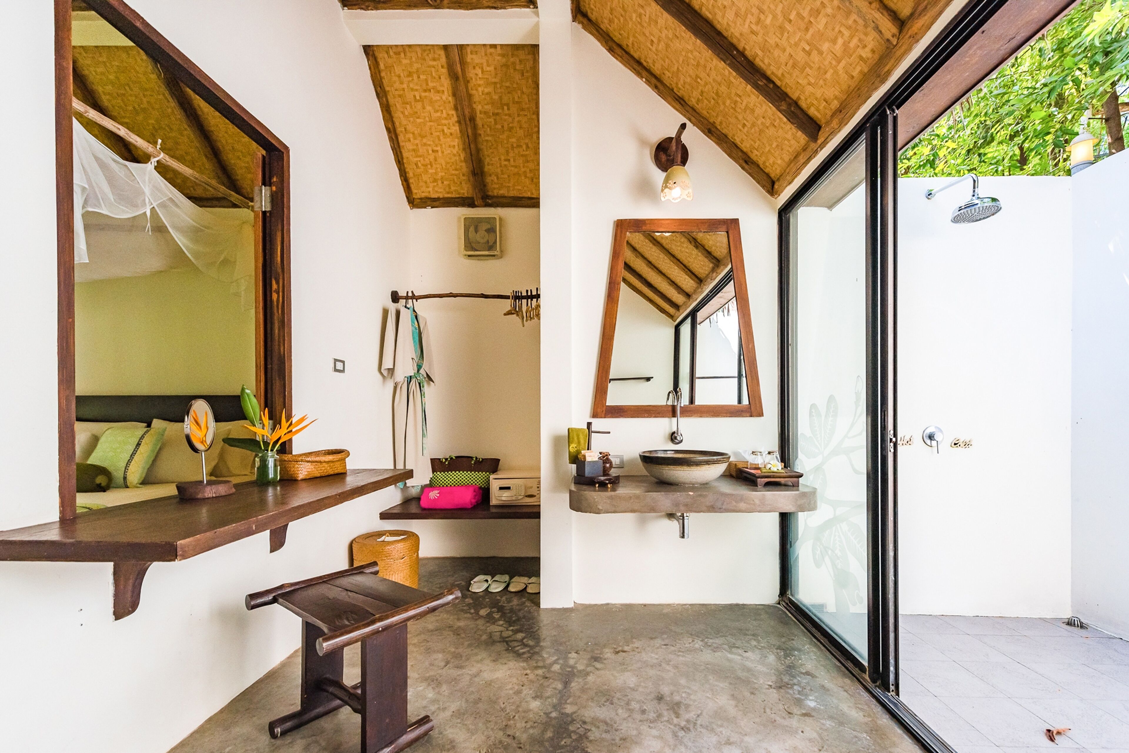 A bathroom with a wooden vanity, a mirror, a sink, and a shower area.