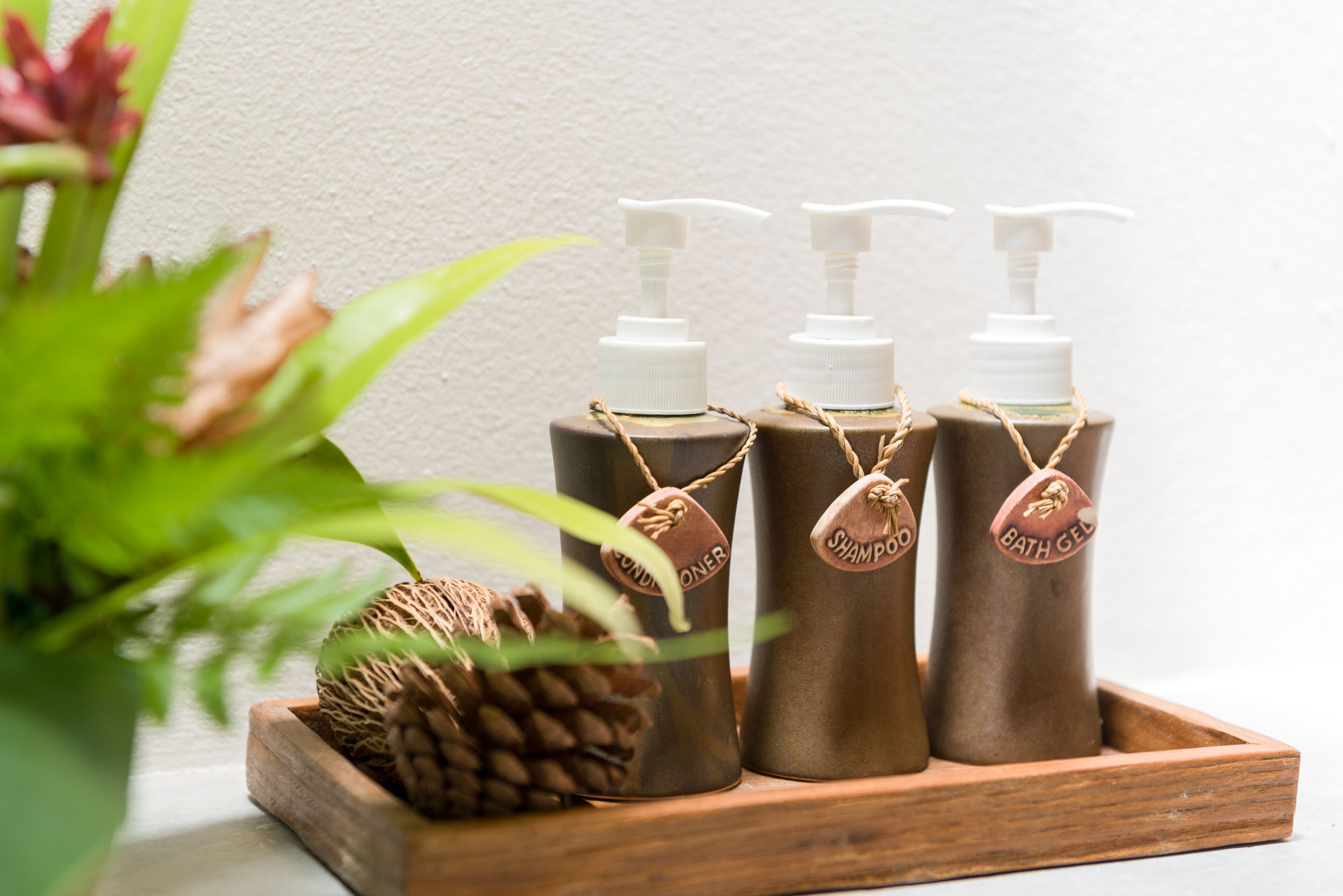 Three bottles of bath products on a wooden tray.