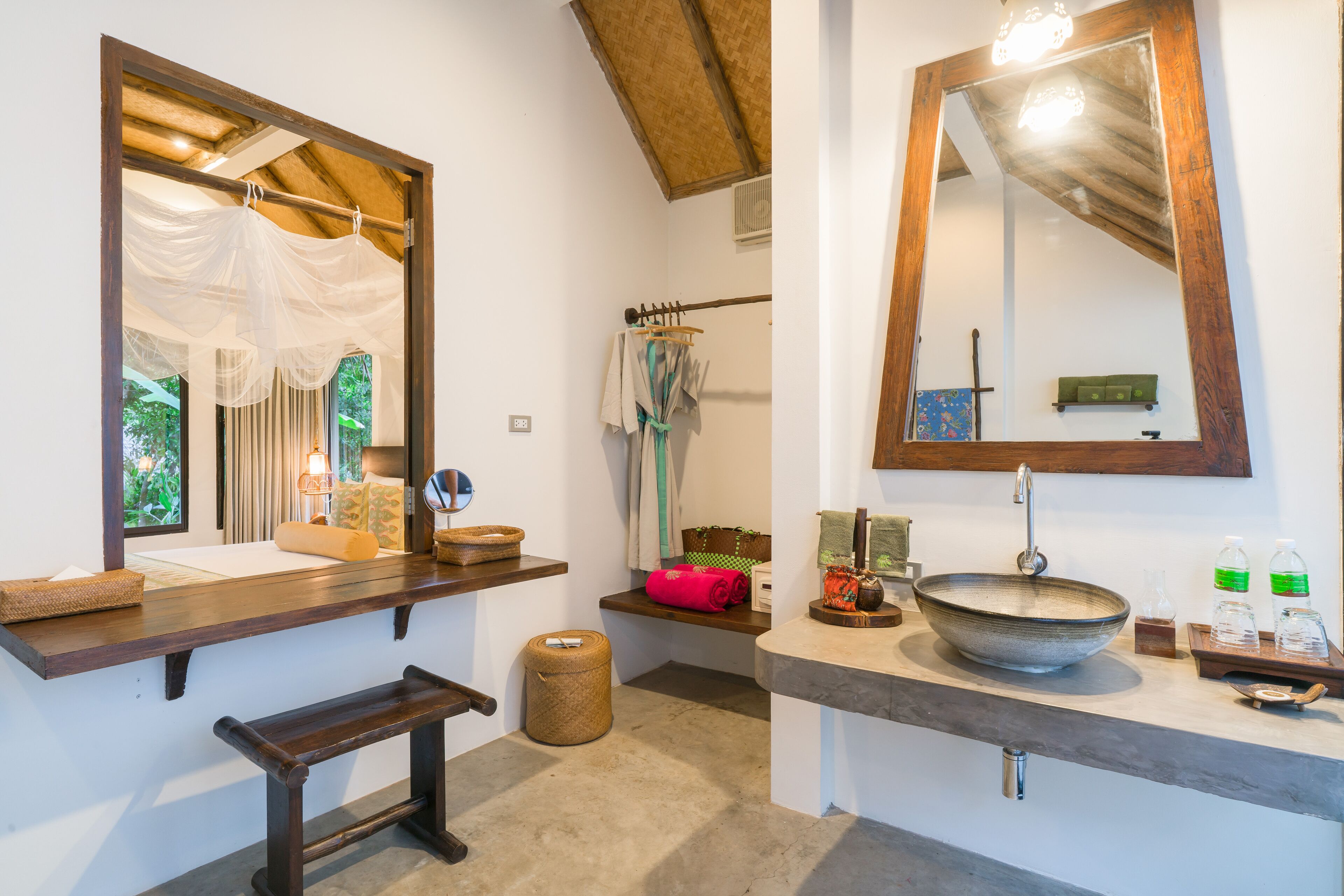 A bathroom with a large mirror, wooden vanity, and a bowl sink.