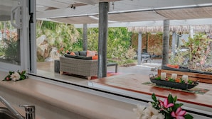 A modern kitchen with a large window, a built-in sink, and a wooden countertop. - Lagoon Breeze Villas (Rarotonga)