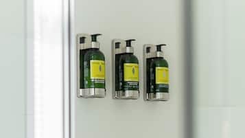 Three bottles of Vervine & Agris shower gel on a bathroom wall.