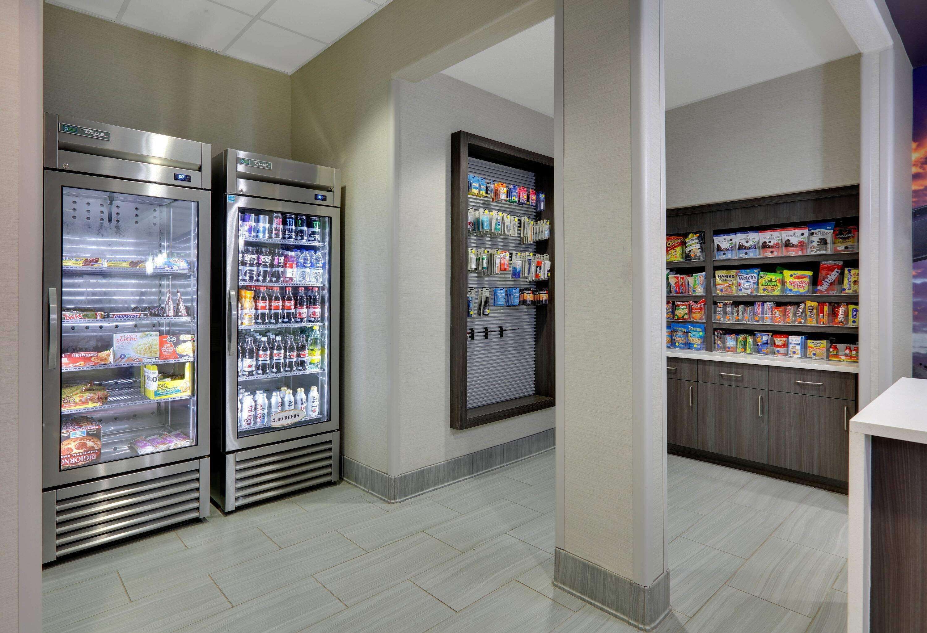 Een nette, moderne lobby met twee drankautomaatjes, een automaat en een snackbar.