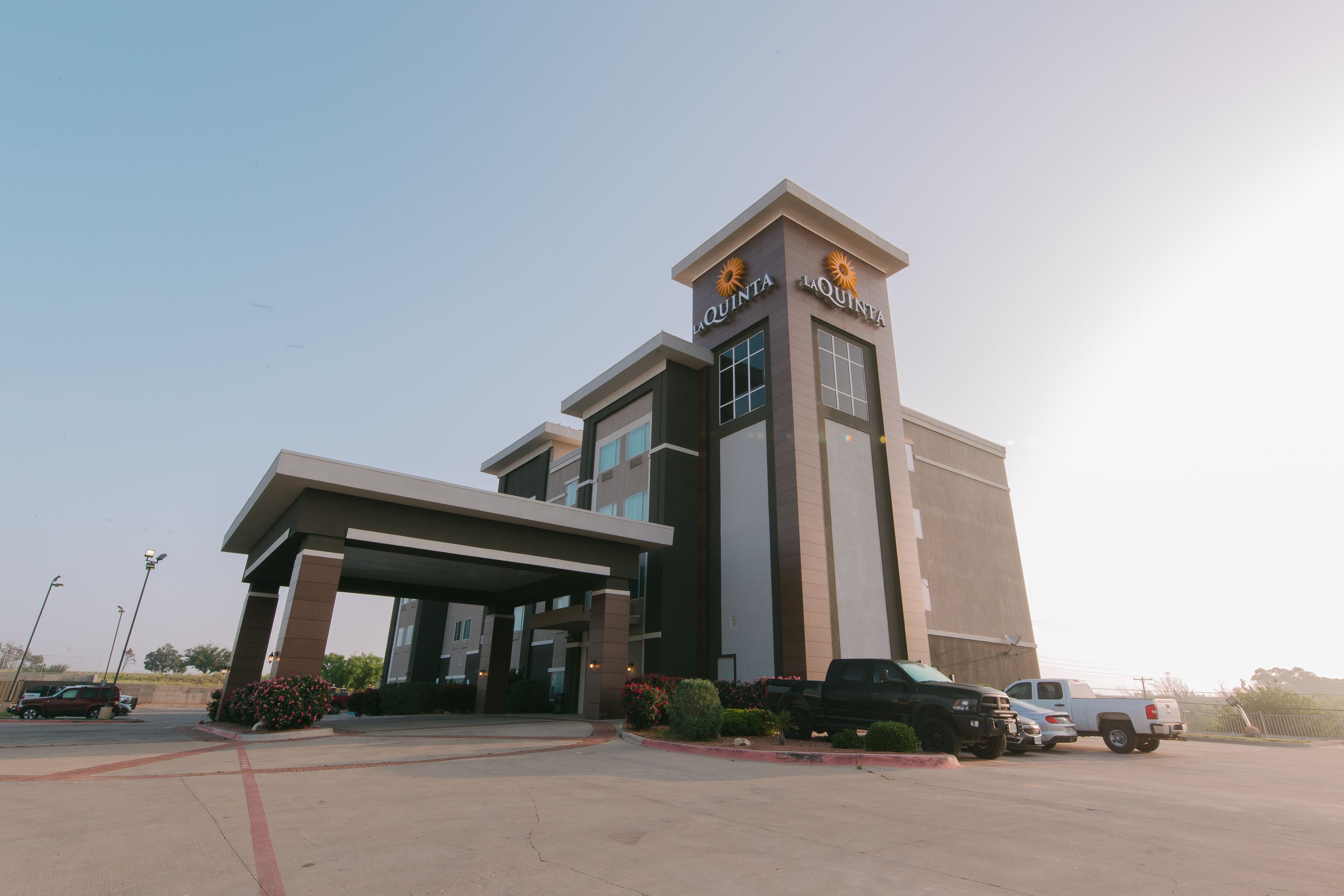 A hotel with a modern design, featuring a covered entrance and a prominent sign.