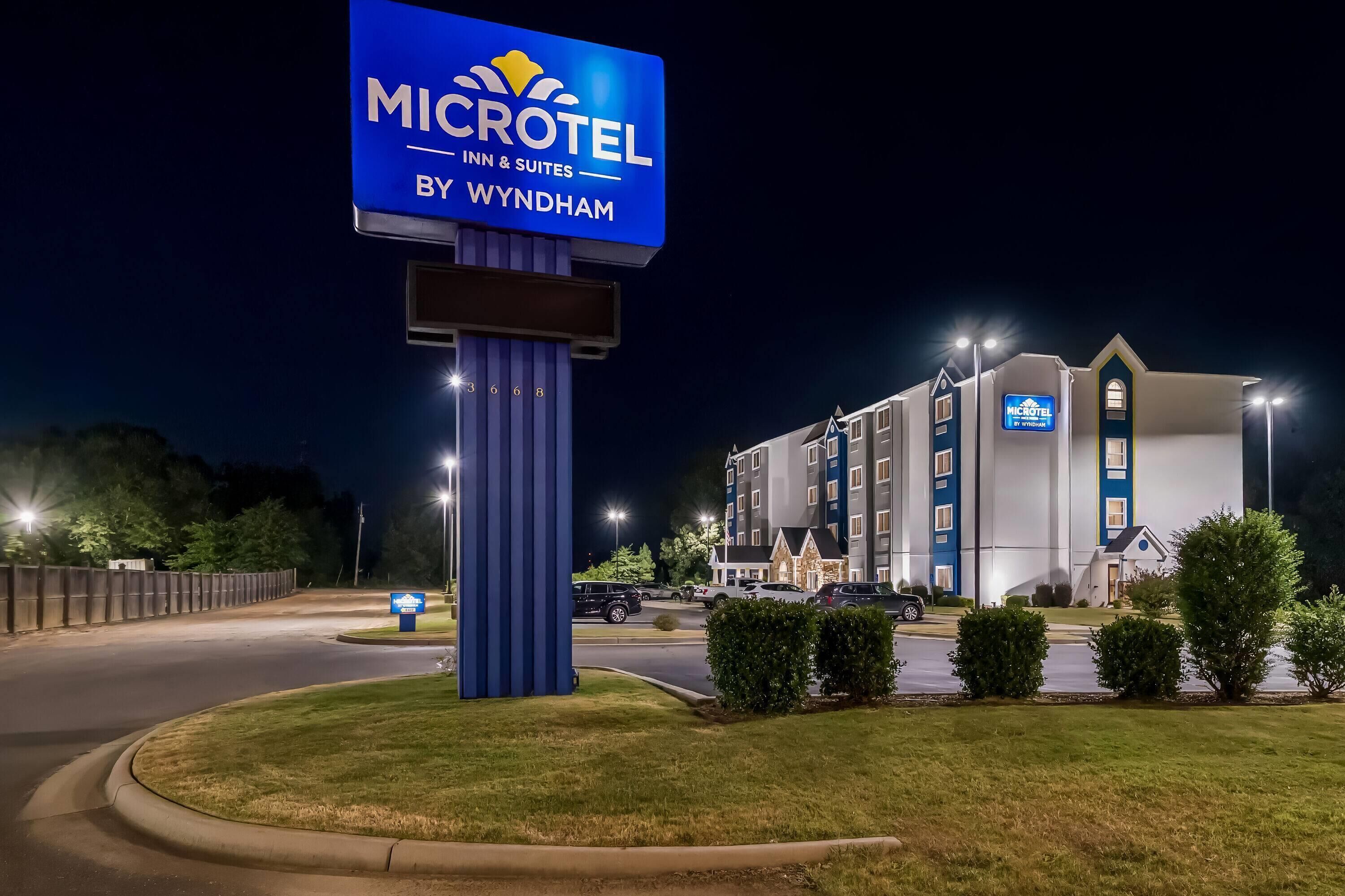 Un bâtiment de la chaîne Microtel Inn & Suites, avec une enseigne bien visible, de nombreuses places de stationnement et une entrée bien éclairée.