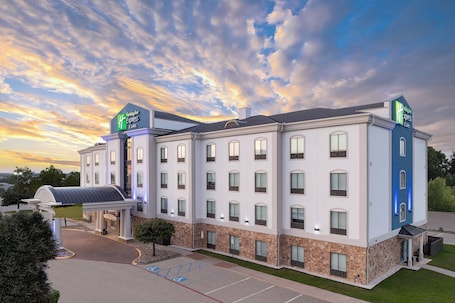 A Holiday Inn Express hotel with a modern design, featuring a large parking lot and a covered entrance.