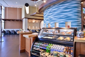 A bakery counter with pastries and a beverage display. - Hyatt Place Garden City (Garden City)