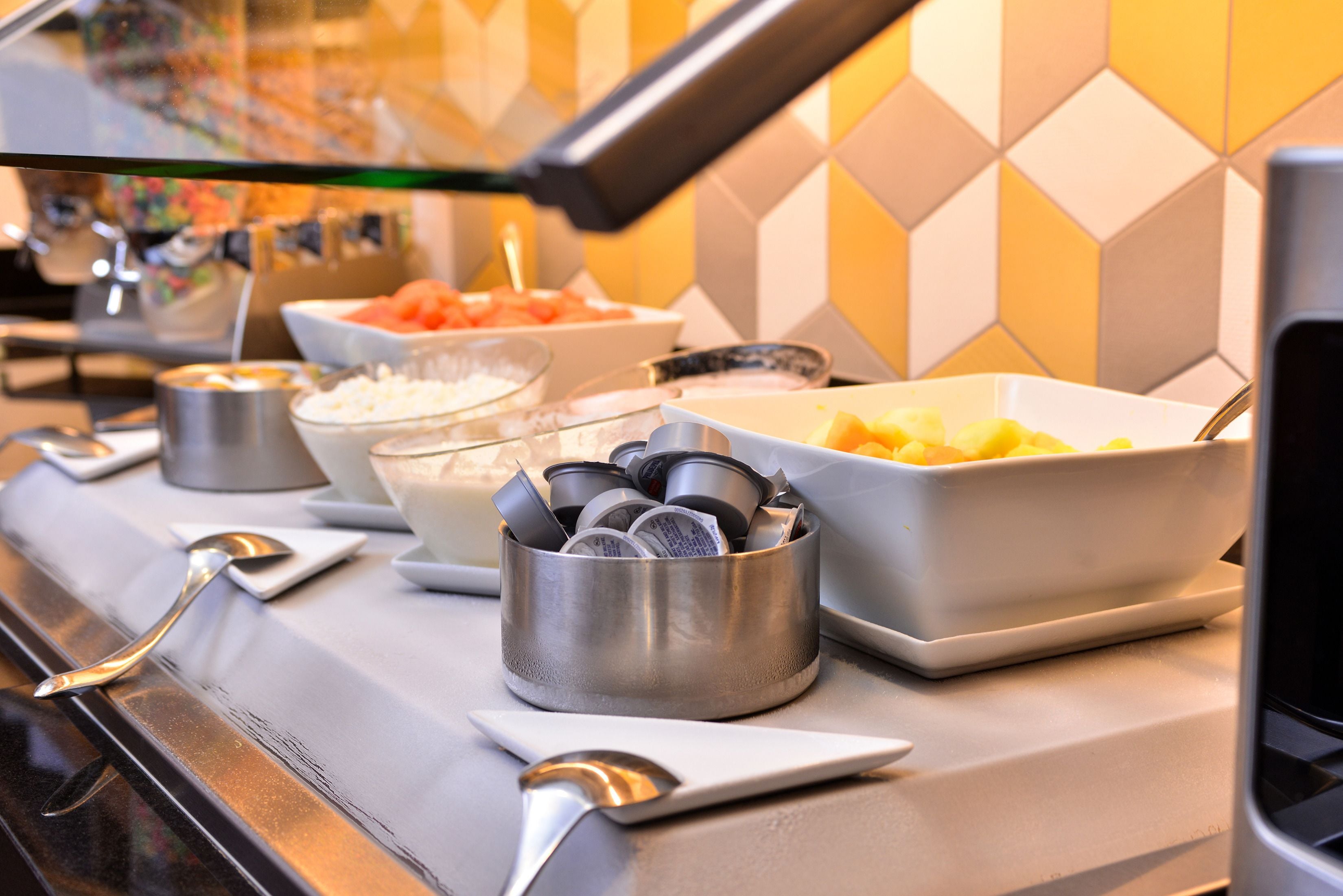 A buffet setup with various food items and utensils.