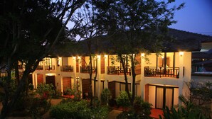 A multi-story building with balconies, surrounded by lush greenery. - The Hive Hotel Samui (Koh Samui)