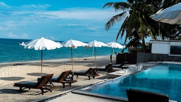 Een buitenzwembad, parasols voor strand/zwembad