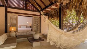 A hammock in a room with a bed, a sofa, and a table.