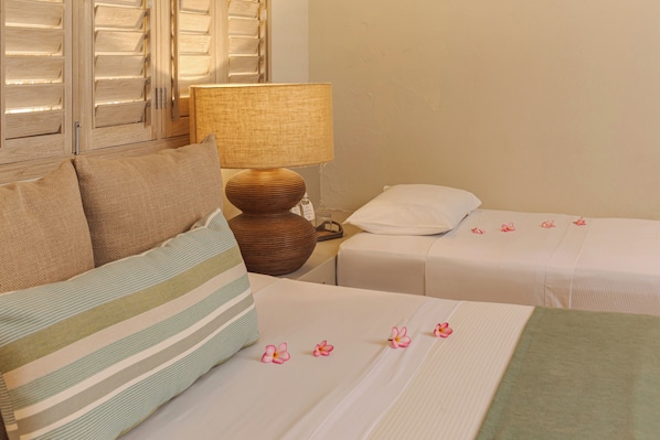 A hotel room with two beds, a lamp, and a window with blinds. - Hotel San Pedro de Majagua (Rosario Islands)