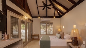 Makuuhuoneessa on sänky, yöpöydällä lamput, pieni pöytä ja kattotuuletin.