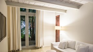 A modern living room with a white sofa, two round side tables, and a floor lamp. - Hotel Boutique Bovedas de Santa Clara By Accor (Cartagena)