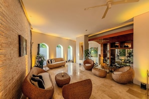 A spacious living area with wicker furniture, a brick wall, and a view of the outdoors. - Hotel Boutique Bovedas de Santa Clara By Accor (Cartagena)
