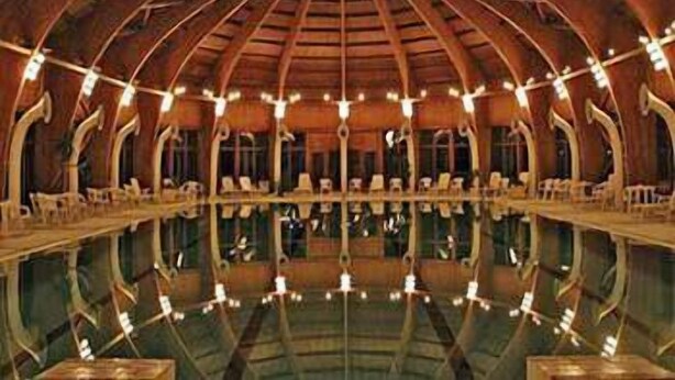 A large, open hall with a high, arched ceiling and multiple rows of seating.