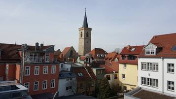 Eine Stadt mit einem markanten Kirchturm, farbenfrohen Gebäuden und einer Mischung aus Wohn- und Geschäftsgebäuden.