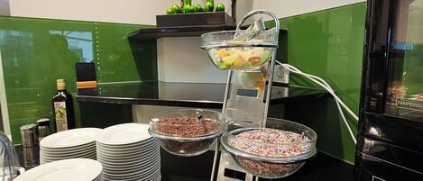 Una mesa de buffet con diversos alimentos y una escultura decorativa de una rana.