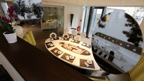 Un comedor moderno con una mesa redonda, sillas y un espejo grande que refleja la habitación.