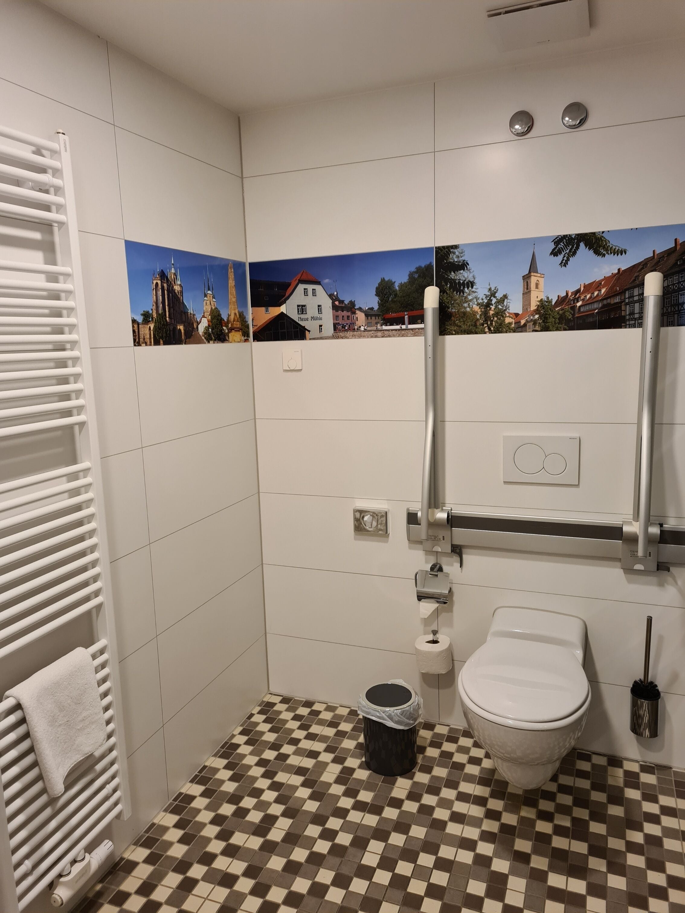 Kylpyhuone, jossa on ruutukuviollinen lattia, wc-istuin, bidee ja patteri.
