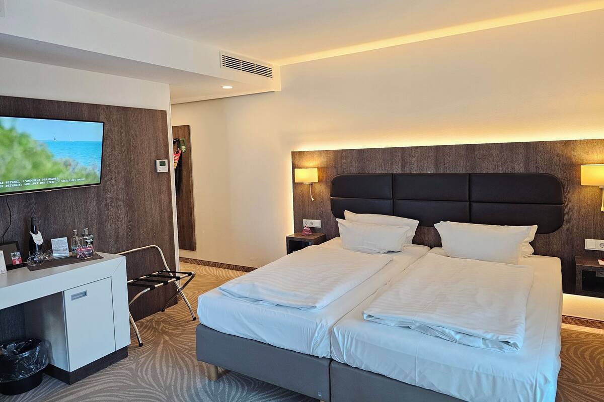 Ein Hotelzimmer mit Bett, Schreibtisch, Fernseher und Meerblick.