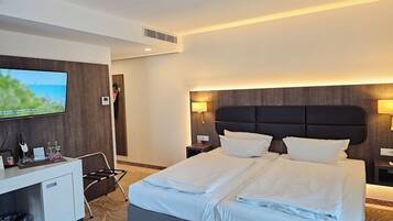 Ein Hotelzimmer mit Bett, Schreibtisch, Fernseher und Meerblick.
