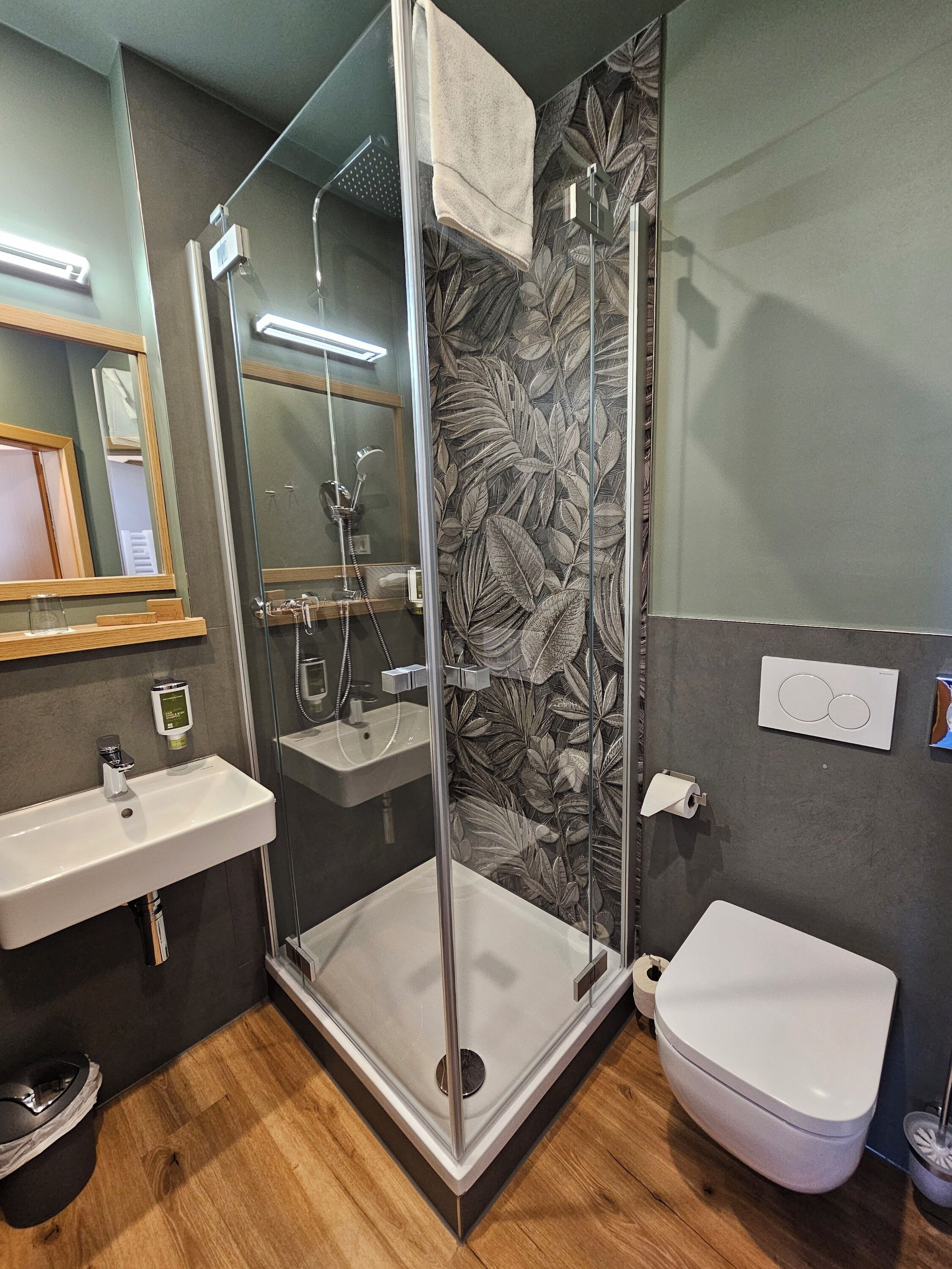A modern bathroom with a glass-enclosed shower, a sink, and a toilet.