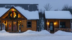 Eine Holzhütte mit verschneitem Dach und einer Veranda.