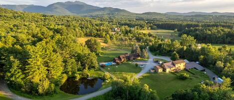 A rural property with a main house, guest cabins, a swimming pool, and a pond.