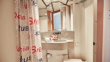 A bathroom with a sink, mirror, and toilet.