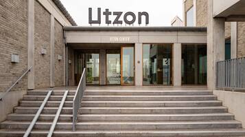 Rakennuksen sisäänkäynti, jossa on kyltti, jossa lukee ”Utzon” ja ”UTZON CENTER”.