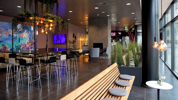 Un interior moderno con una zona de bar, asientos y un ventanal grande.