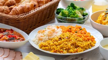 A table with various dishes including rice, shrimp, and vegetables.