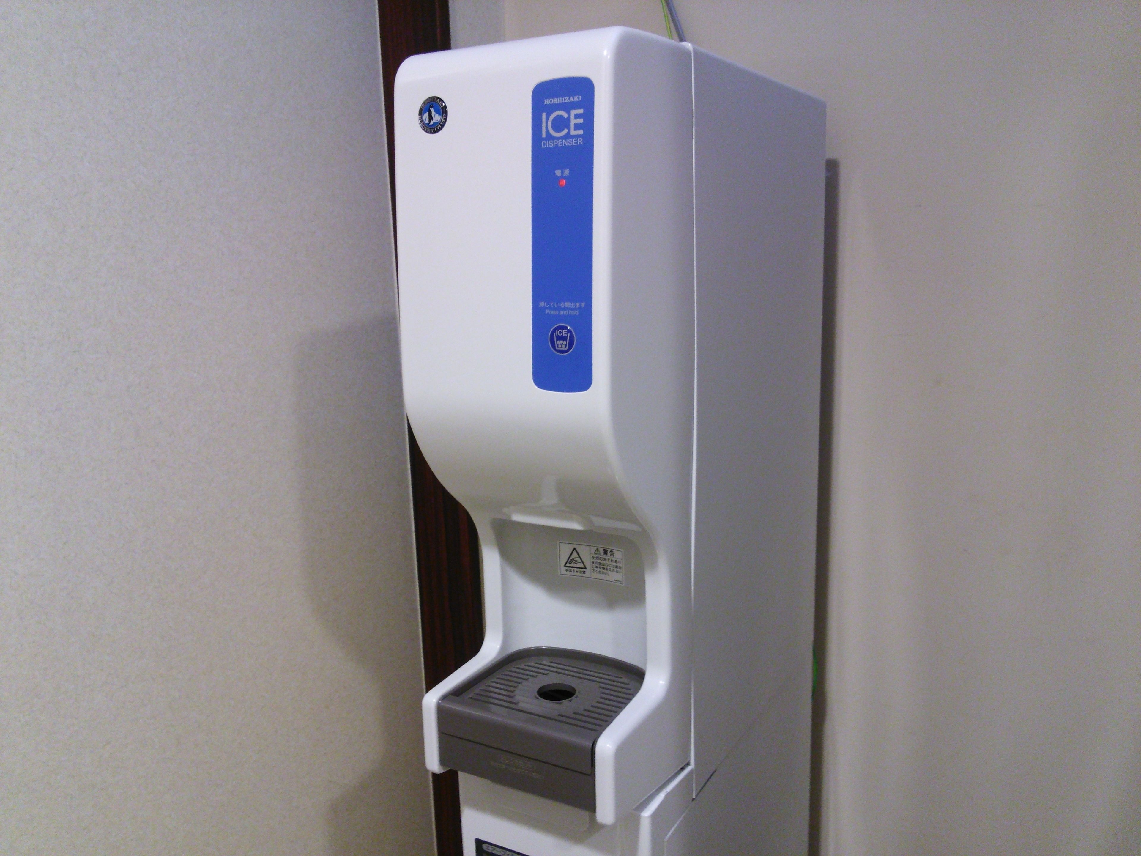 A white ice dispenser with a blue label and a grey dispensing area.