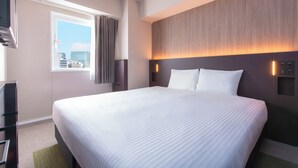 A hotel room with a large bed, a window with curtains, a wall-mounted TV, and a wall-mounted light. - Hotel Villa Fontaine Tokyo - Kudanshita (Tokyo)