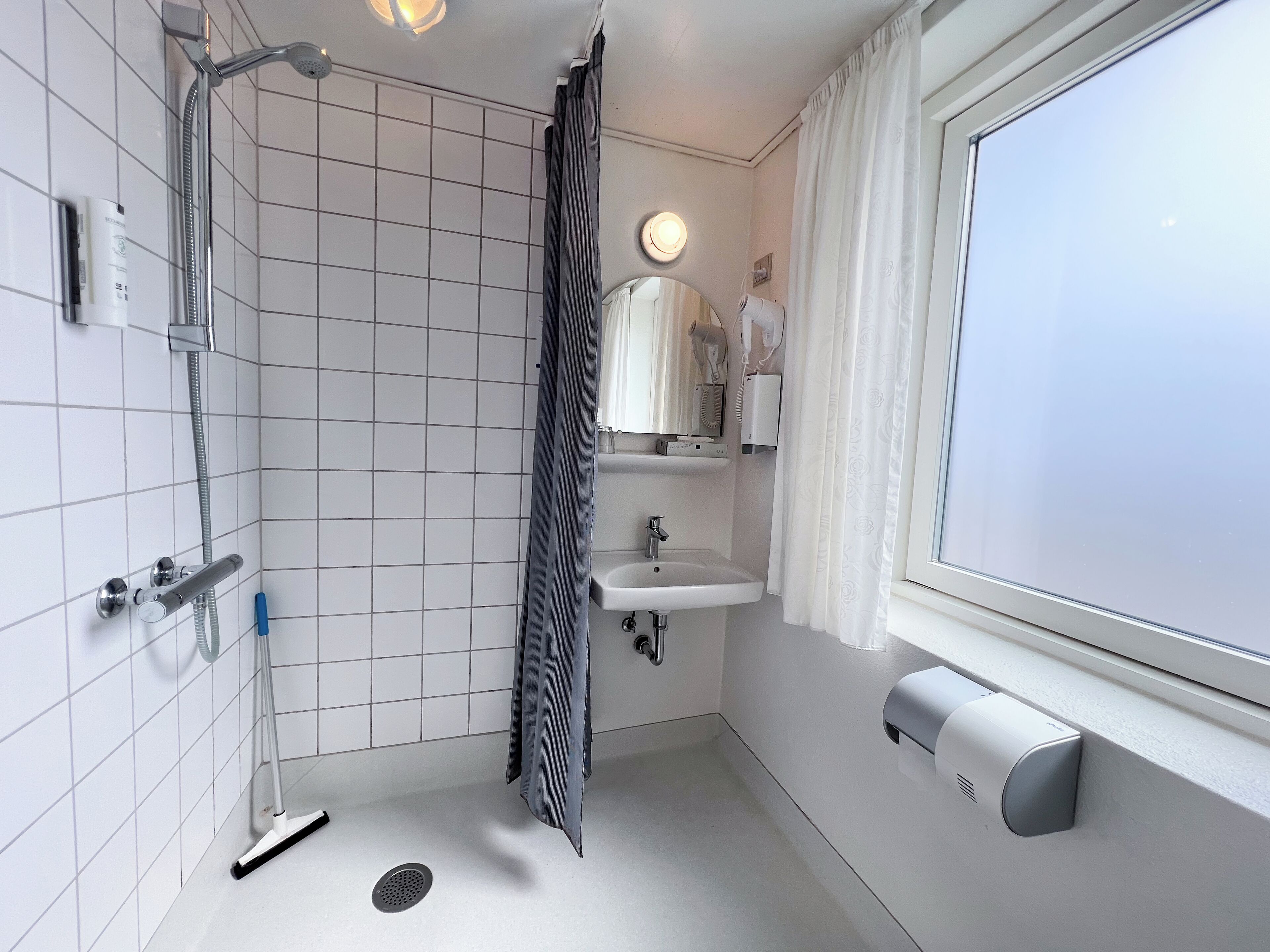 Un baño moderno con ducha, lavamanos e inodoro.