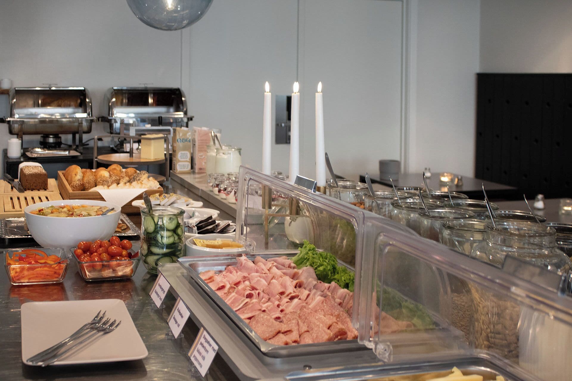 A buffet with various food items, including meats, vegetables, and bread.