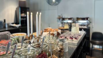 Una mesa de buffet con diferentes alimentos y velas.