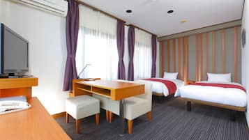 A hotel room with a desk, two beds, a TV, and a telephone.