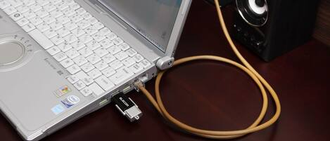 A laptop with a keyboard, a monitor, and a speaker connected by a cable.
