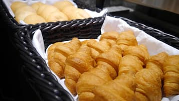 A basket of freshly baked croissants and bread rolls.