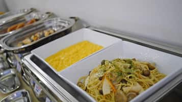 Un bufé con pasta y huevos revueltos.